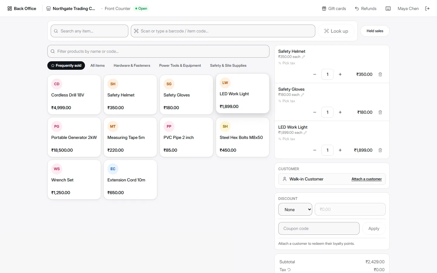 AccountDesq POS checkout screen showing a product grid of hardware items on the left and a cart with Safety Helmet, Safety Gloves, and LED Work Light line items, customer, discount, and coupon fields on the right